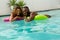 Couple floating on inflatable tube in swimming pool