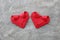 couple folding red paper hearts on cement wall for valentine pat