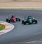 Couple of Formula cars battle and attempt overtaking at turn challenging during the