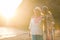 Couple of friends females outdoor at the beach during a beautiful sunset with golden light. ocean and shore in background for