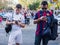 Couple of friends supporting Real Madrid and Barcelona watching their Smartphones at Santiago Bernabeu Stadium Gates before the Re
