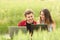 Couple or friends watching laptops in a field