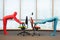 Couple in full body elastic suits exercising with chairs in office
