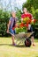 Couple in garden with barrow and flowers