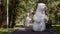 A couple of a giants polar bears puppets doll dances in a green park, in a background of green trees, in summer