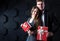 Couple with gifts. Beautiful man and woman holding gift boxes on a dark background