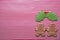 Couple gingerbread man with omela leaves on stripe background. Christmas gingerbread man cookies top view, text space