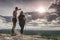 Couple, girl and boy, on hilly path. Both watch