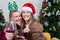 Couple with glasses of red wine near fireplace, Beautiful caucasian young woman in sweater and with santa hat on head sitting on