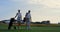 Couple golf players discuss sport course outside. Two golfers walk grass field.