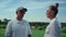 Couple golf players talk at grass course field. Golfers team chat on summer day.