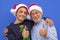 Couple of grandfather with teenager grandson smile doing ok sign with hands, wearing Christmas sweater and santa hats. Concept of