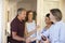 Couple greeting their guests at the door of their home