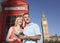 Couple With Guidebook Against London Phone Booth And Big Ben Tow