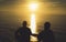 Couple guy on background beach ocean sunrise, silhouette two people cuddling and looking on rear view evening seascape, romantic