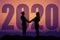 Couple hand in hand silhouette with big new year 2020 and sunset