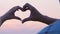 Couple hands making heart sign sky background, love symbol, romantic relations