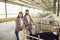 Couple of happy farmers checking on calves in big barn on livestock farm in countryside