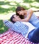 Couple, happy and park for picnic with embrace for bonding, love and sunshine on grass outdoors. Man, woman and smile in