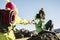 Couple of happy woman helping eachother to arrive to the top of the mountain - enjoy the outdoor trekking hiking activity - clear