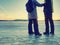 Couple has fun during winter walk on ice of frozen lake