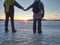 Couple has fun during winter walk on ice of frozen lake