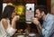 Couple Having Coffee Sitting In Cozy Cafe, Side View