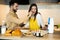 Couple are having fun while cooking. They look happy being together in the kitchen together. They are baking some