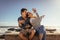 Couple having fun sitting on sea wall