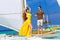 Couple having fun on tropical beach on the sailboat. Summer vacation concept.