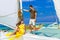 Couple having fun on tropical beach on the sailboat. Summer vacation concept.