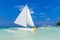 Couple having fun on tropical beach on the sailboat. Summer vacation concept.