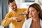 Couple having hair cut at home during quarantine coronavirus pandemic, online hairdressing on tablet