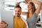 Couple having hair cut at home during quarantine coronavirus pandemic, online hairdressing on tablet