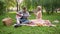 Couple having romantic date, singing songs and playing guitar, sitting in park