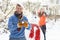 Couple Having Snowball Fight In Garden