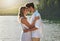 Couple, head touch and hug by lake for outdoor date, romantic adventure and summer love in nature. Man, woman and