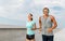 Couple with headphones running outdoors