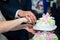 The couple held hands to cut the first piece, beautiful, wedding cake for their beloved parents