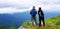 Couple hiker with backpack standing on the top of mountain with blue sky, white cloud and mist