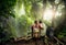 Couple hikers with backpacks enjoying view waterfall in rain for