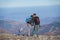 Couple hikers with backpacks on the ridge of the mountain