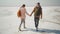 couple hikers with backpacks walking holding hands on deserted pink white salty coast of Sivash Pink Salt Lake.