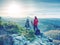 Couple of hikers look down into fogy valley. Photographer stay