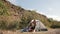 Couple of hikers resting near the tent in the warm sunshine