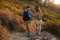 Couple of hikers walking down the hill. Man and woman with backpack walking down the mountain trail