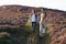 Couple Hiking Across Moorland Covered With Heather