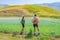Couple hiking in blooming cultivated fields, famous colourful flowering plain in the Apennines, Castelluccio di Norcia highlands,