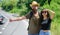Couple hitchhikers travelling summer sunny day. Couple travelers man and girl hitchhiking at edge road nature background