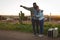 Couple hitchhiking on dirt track